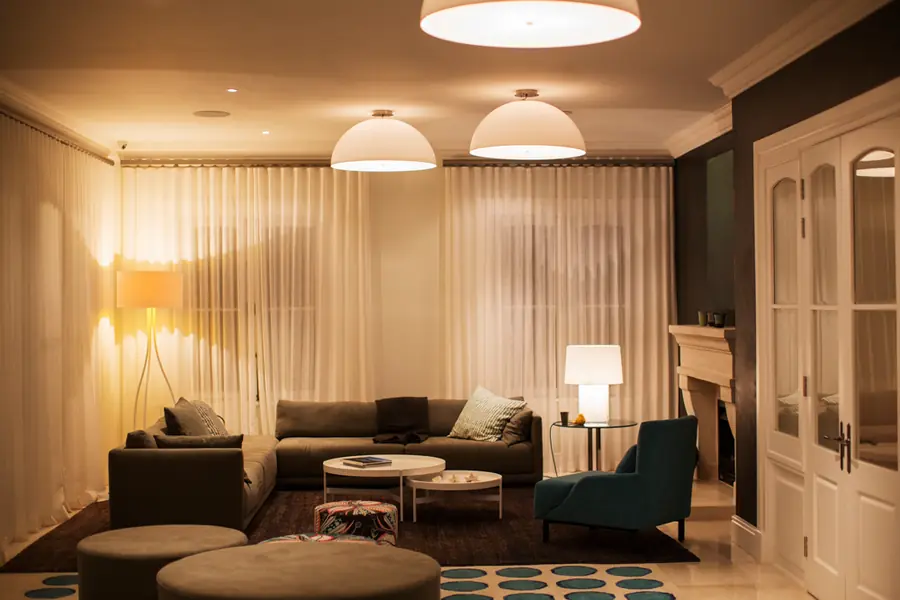 A living room lit in the evening by pendant lights and lamps