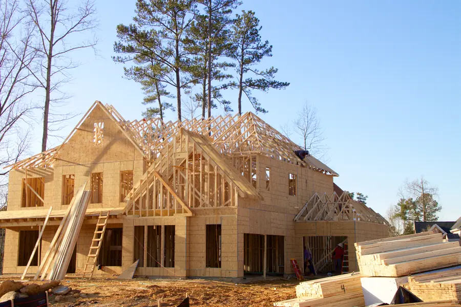 A house under construction with framing and roof trusses exposed